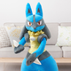 A life-sized Lucario stands in front of a sofa.